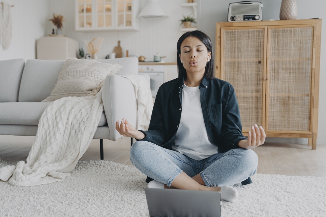 female-practices-yoga-at-laptop-breathing-deep, einfache Atemübungen